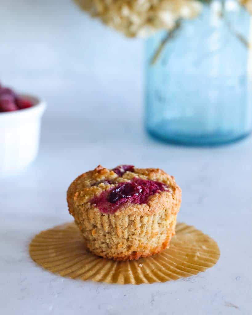a single orange cranberry muffin with the liner removed