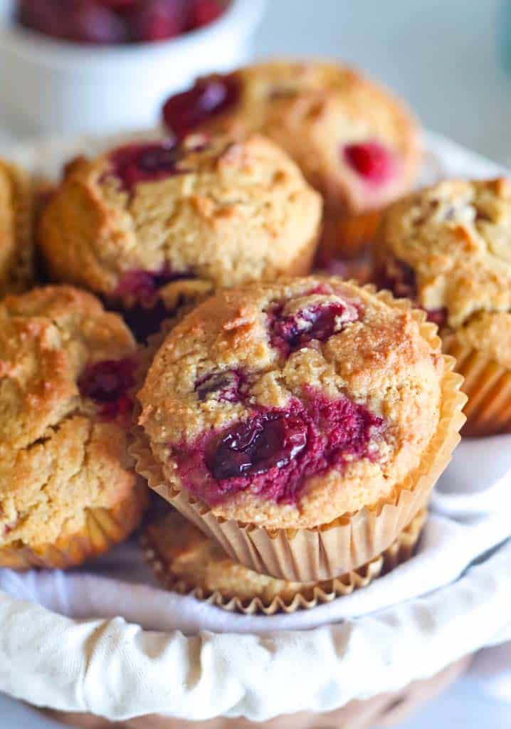 a basket full of cranberry orange muffins