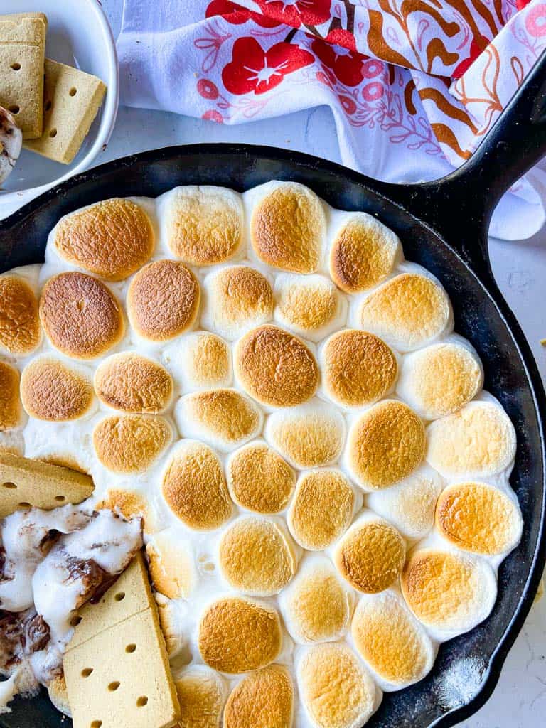 close up view of graham crackers in a skillet full of s'mores dip