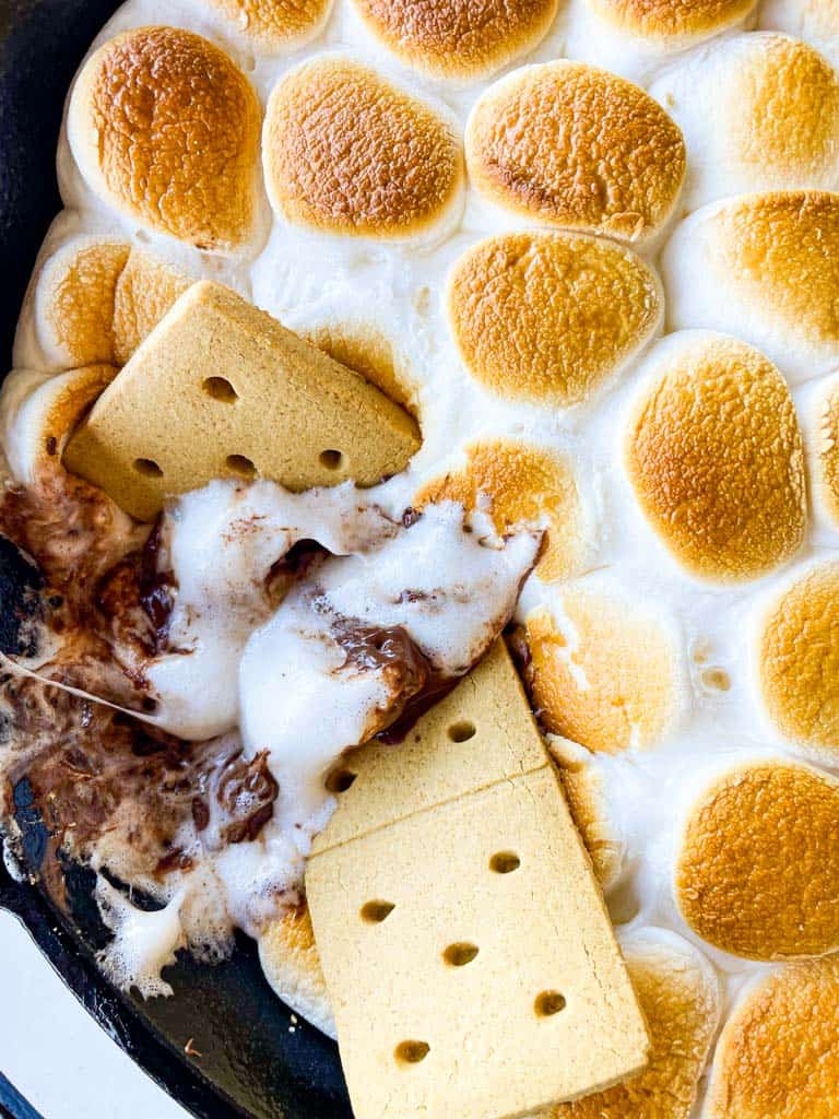 graham crackers in a skillet full of s'mores made in the oven