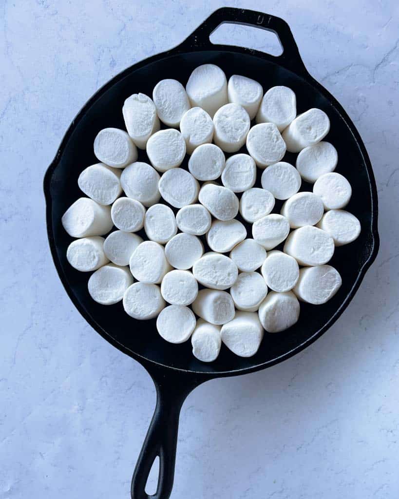 marshmallows covering chocolate in a cast iron skillet