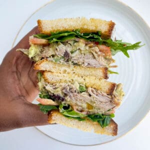 a hand holding a sliced sandwich