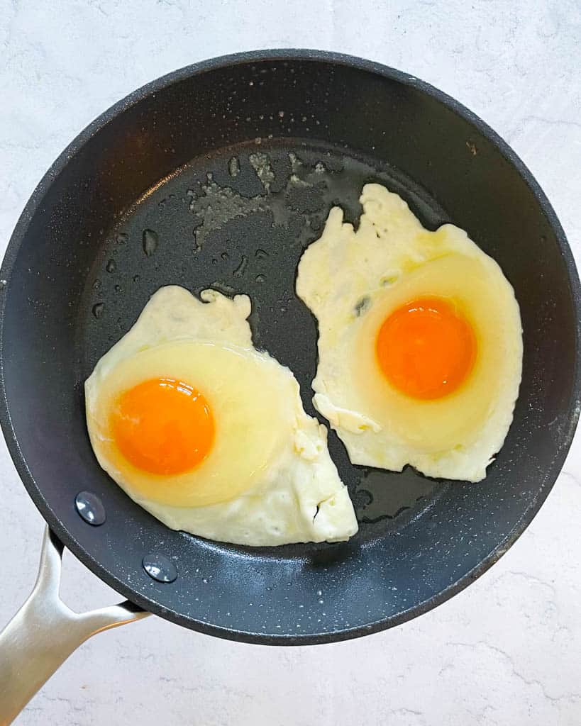 two eggs cracked in a small skillet to make over medium eggs