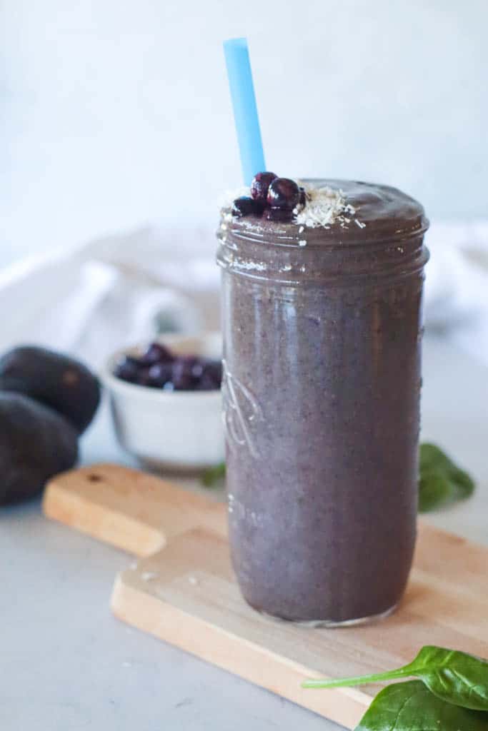 blueberry smoothie with avocados and a bowl of blueberries in the background