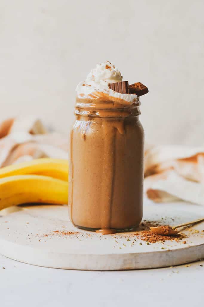 chocolate maca smoothie topped with whipped cream and garnished with chocolate 