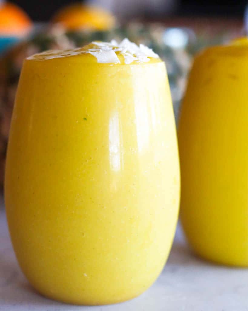 close up view of a cup full of mango pineapple smoothie