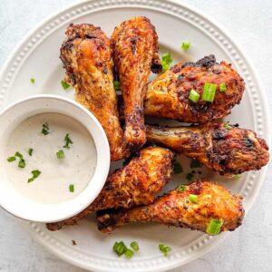 plated air fryer chicken legs with dipping sauce