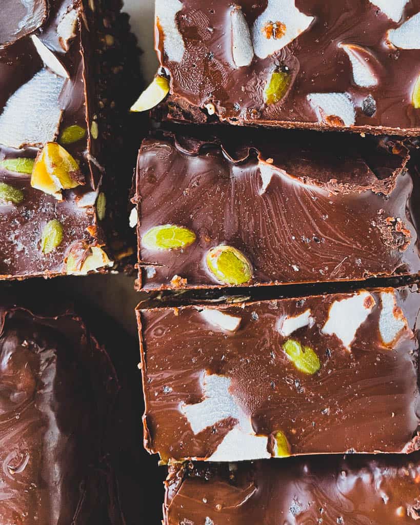 Close shot of chocolate energy bar topping with shredded coconut and pumpkin seeds