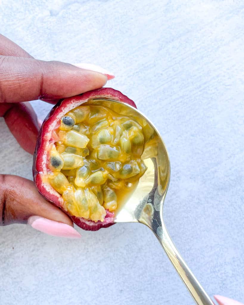 a spoon scooping out passion fruit