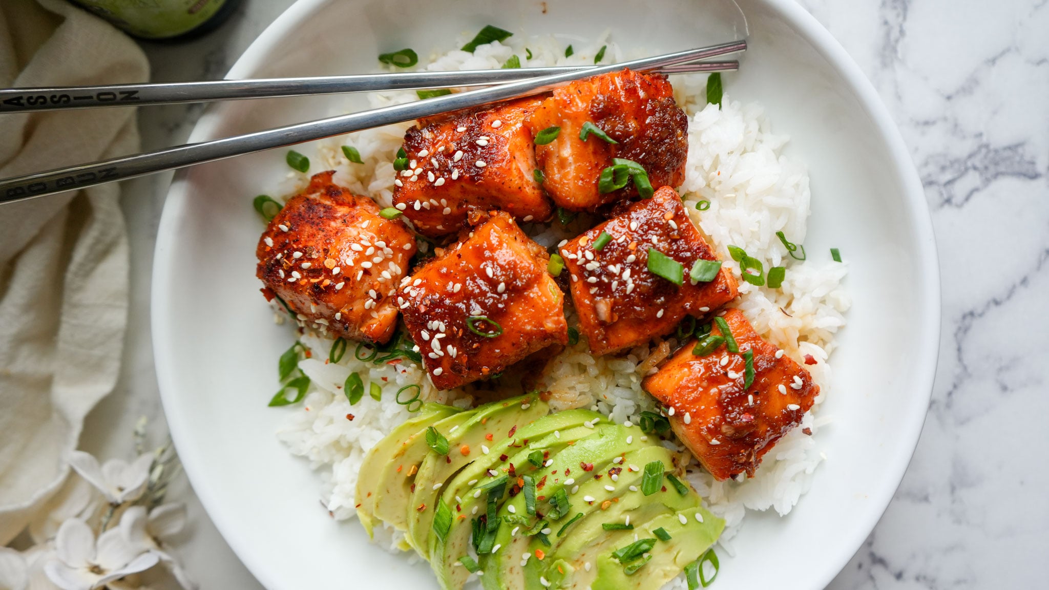 salmon bites on a plate with rice and avocado