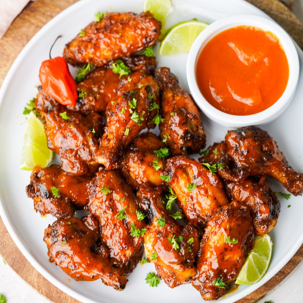 overhead view of plated mango habanero wings with a side of sauce