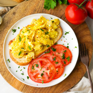 scrambled duck eggs on toast with sliced tomatoes