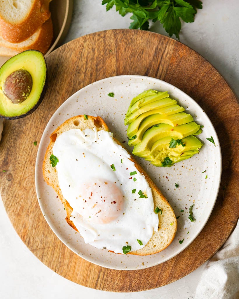 over easy duck eggs on toast with a side of sliced avocado