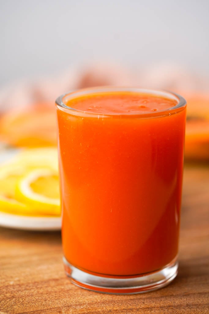 close up view of a clear glass full of papaya juice
