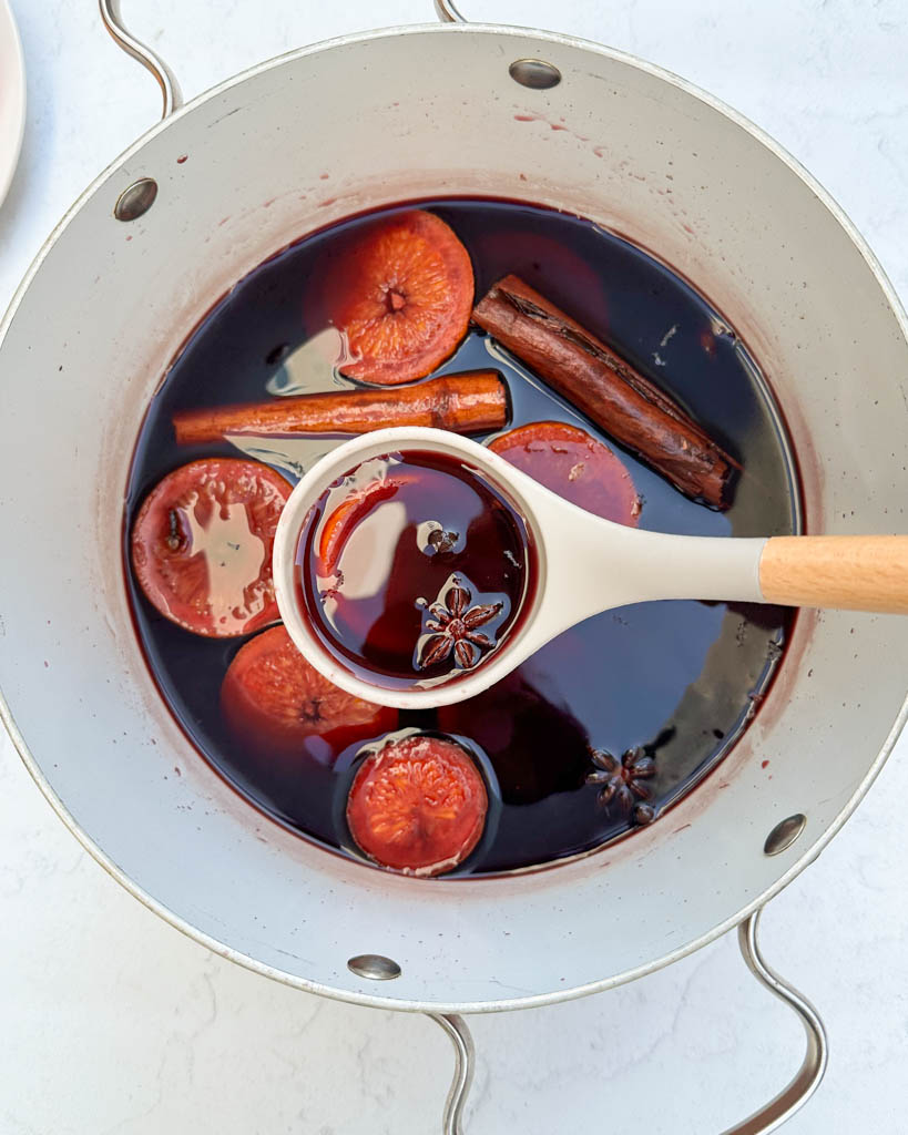 mulled wine in a large pot with a ladle full of the mixture