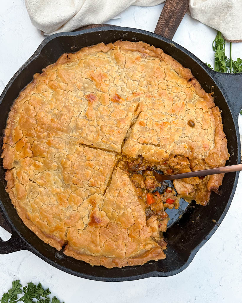 a skillet full of chicken pot pie with a slice removed