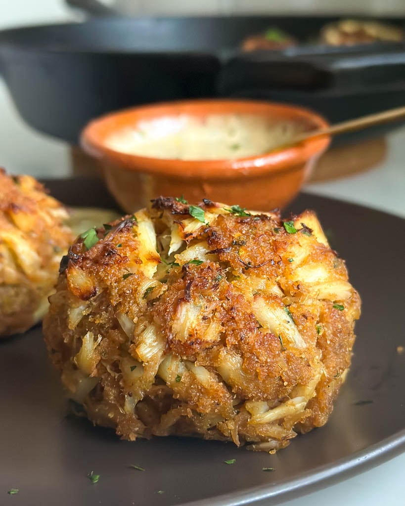 close up view of Maryland crab cake with aioli in background