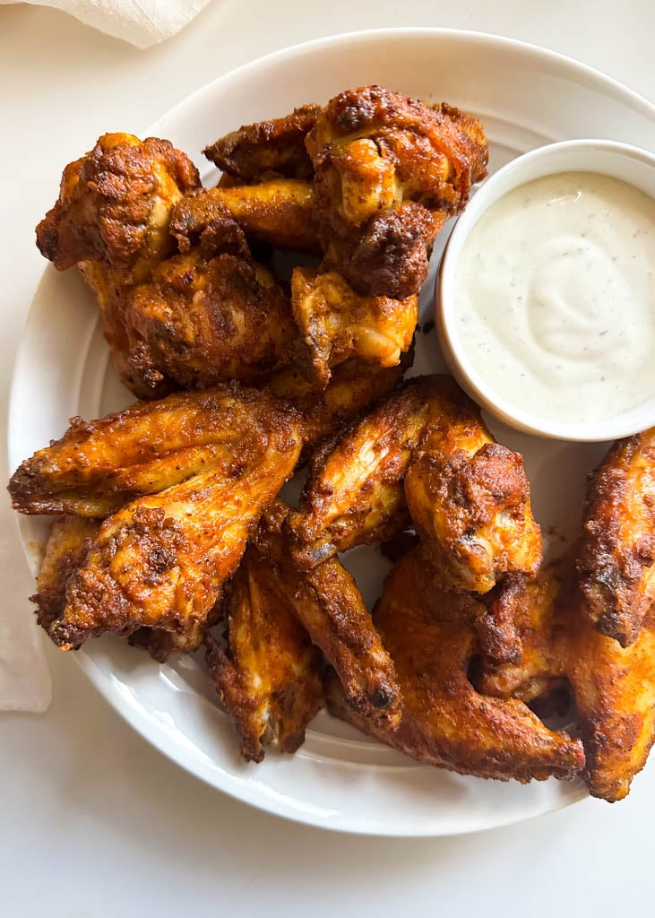 plated buffalo old bay wings with a side of ranch dipping sauce