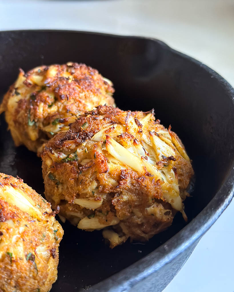 close up view of baked Maryland crab cakes in skillet