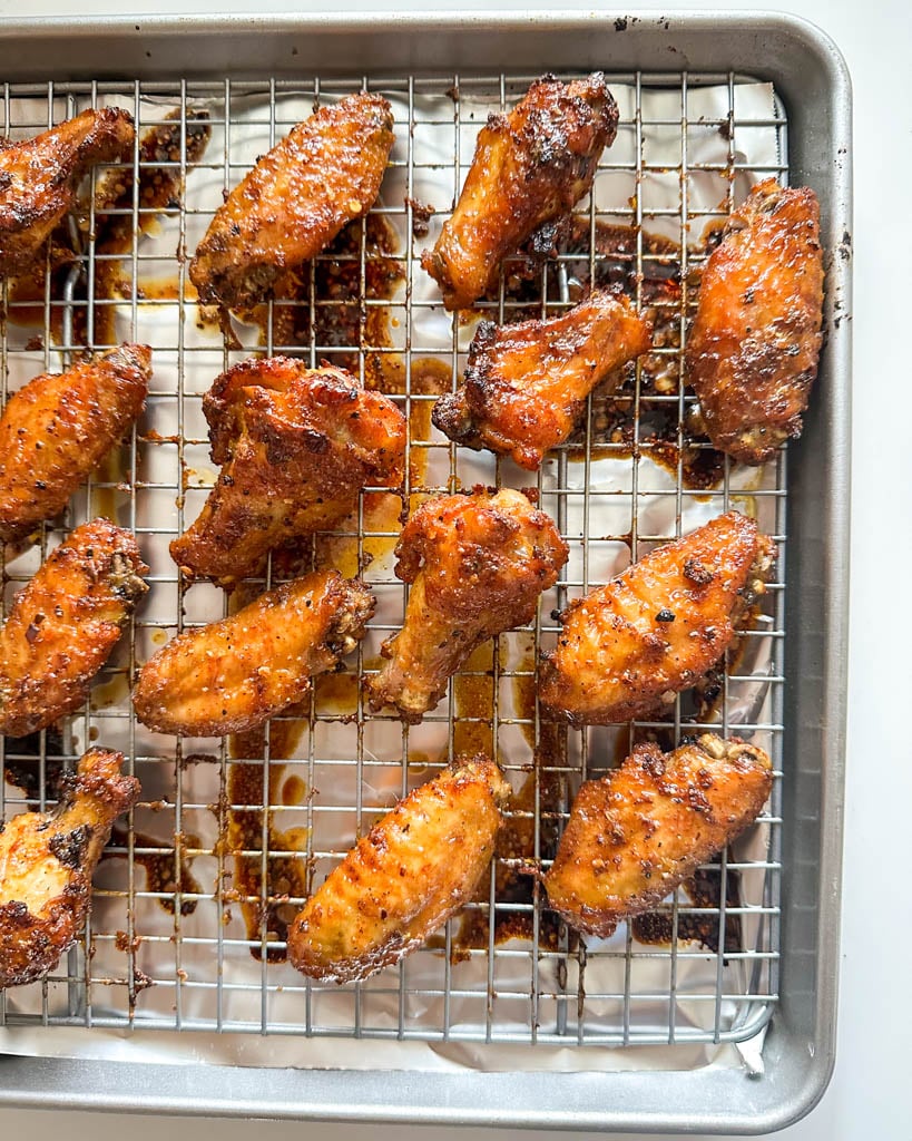 chicken wings on a cooling rack over a baking sheet
