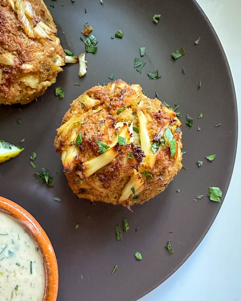 plated crab cakes with partial view of aioli sauce