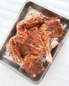 dry brine seasoning rubbed on the back side of a butterflied turkey placed in a roasting tray