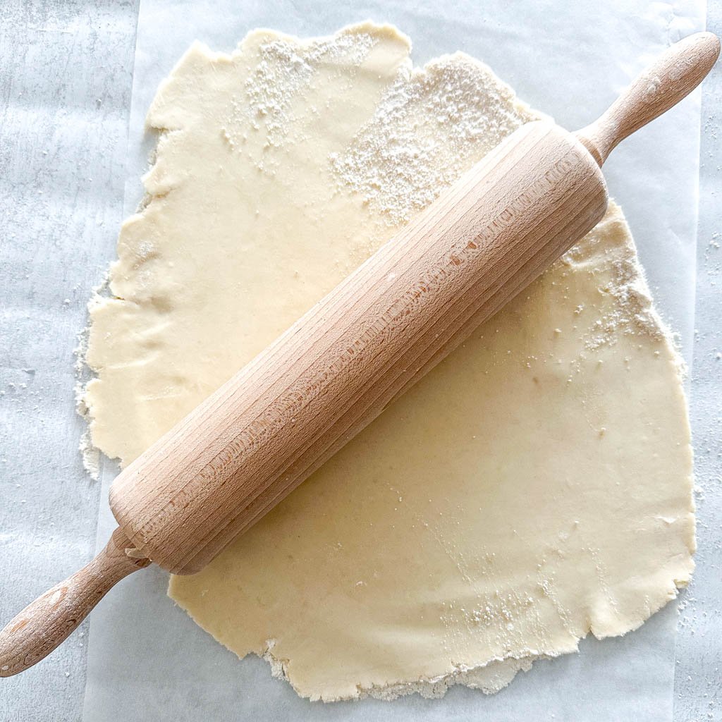 gluten free galette dough rolled out with a rollin pin on top