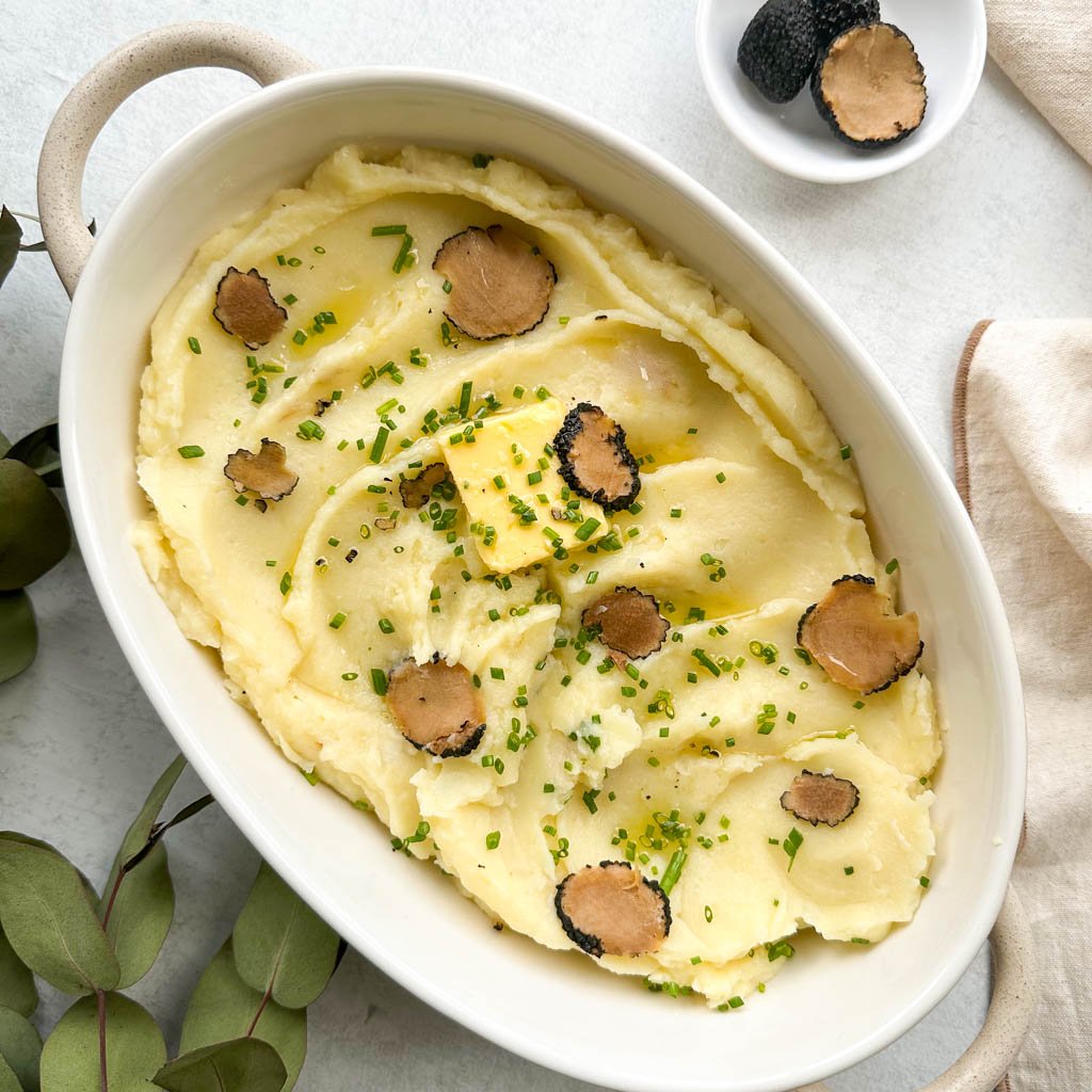 a pot of truffle mashed potatoes topped with a pat of butter