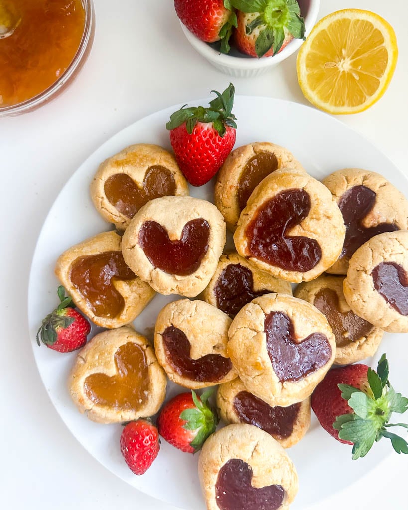 a plate of strawberry and apricot thumbprint cookies