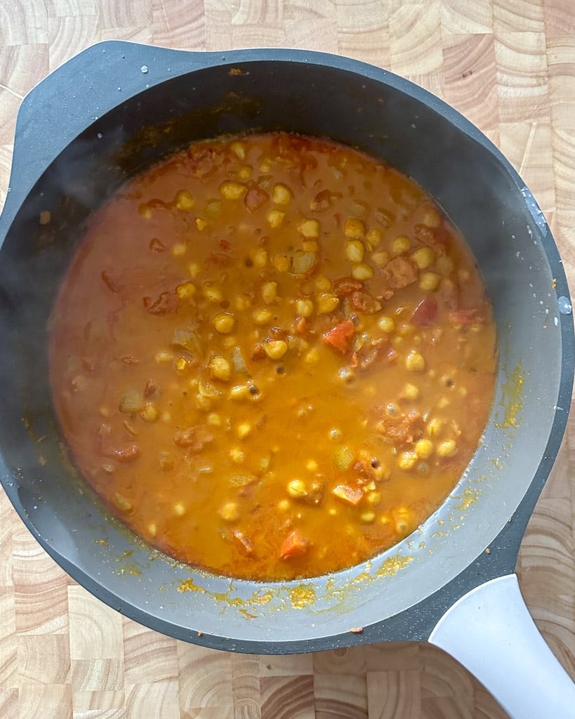 coconut milk mixture in a large pot with chickpeas and tomato onion and spices