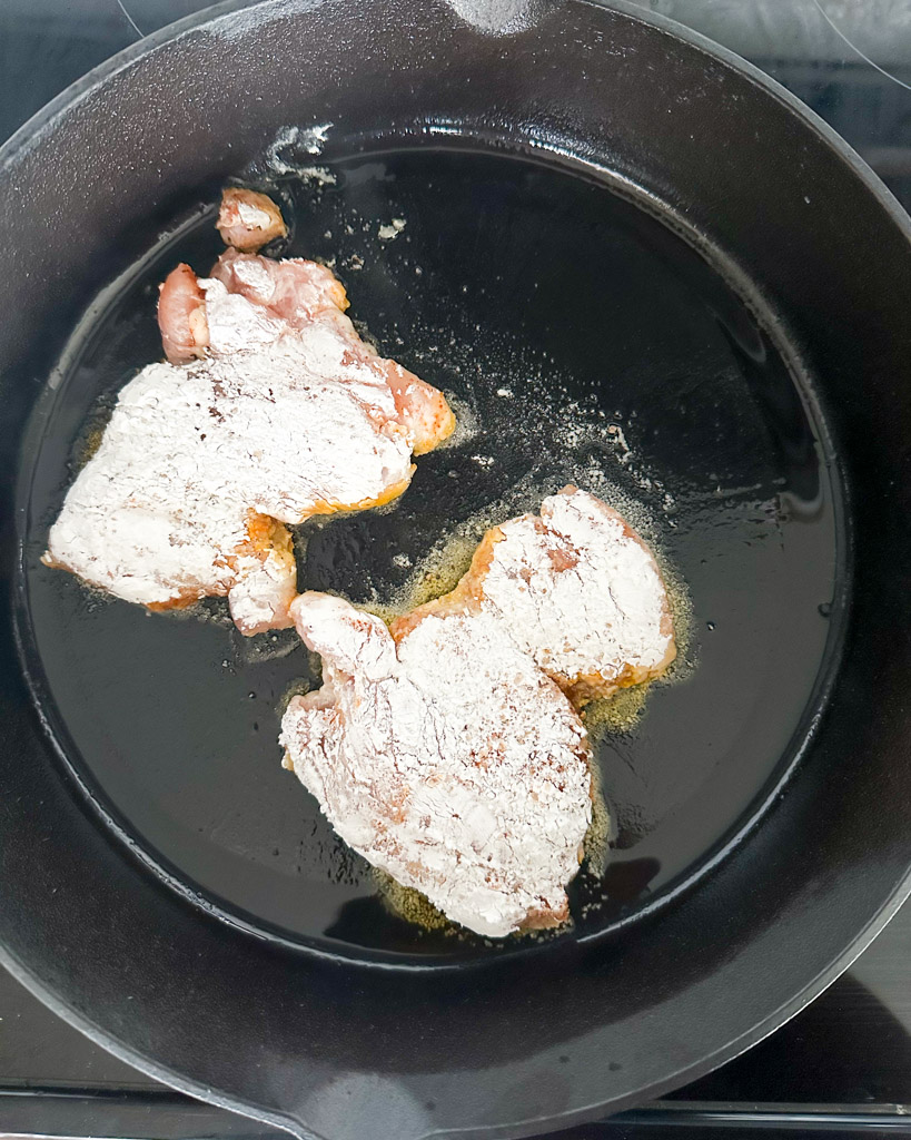 two chicken thighs in a cast iron skillet 