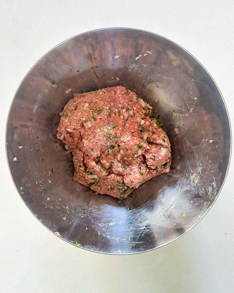 minced lamb with spices and herbs in a large mixing bowl