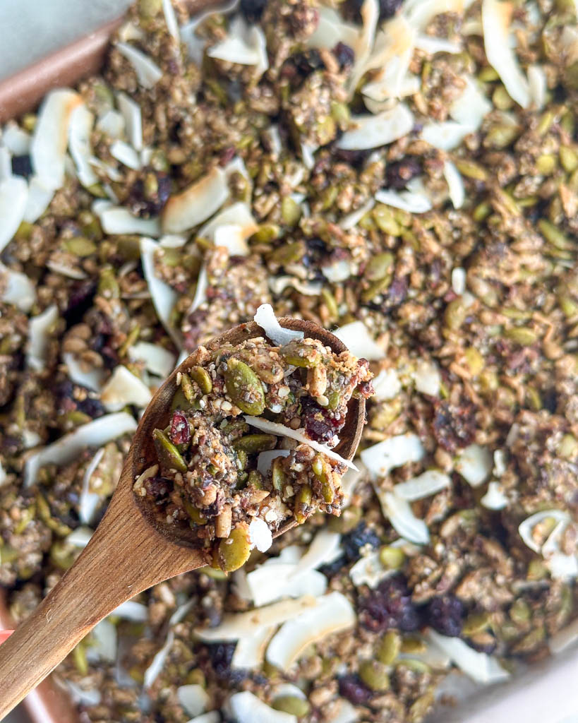 super seed granola on a wooden spoon to show texture