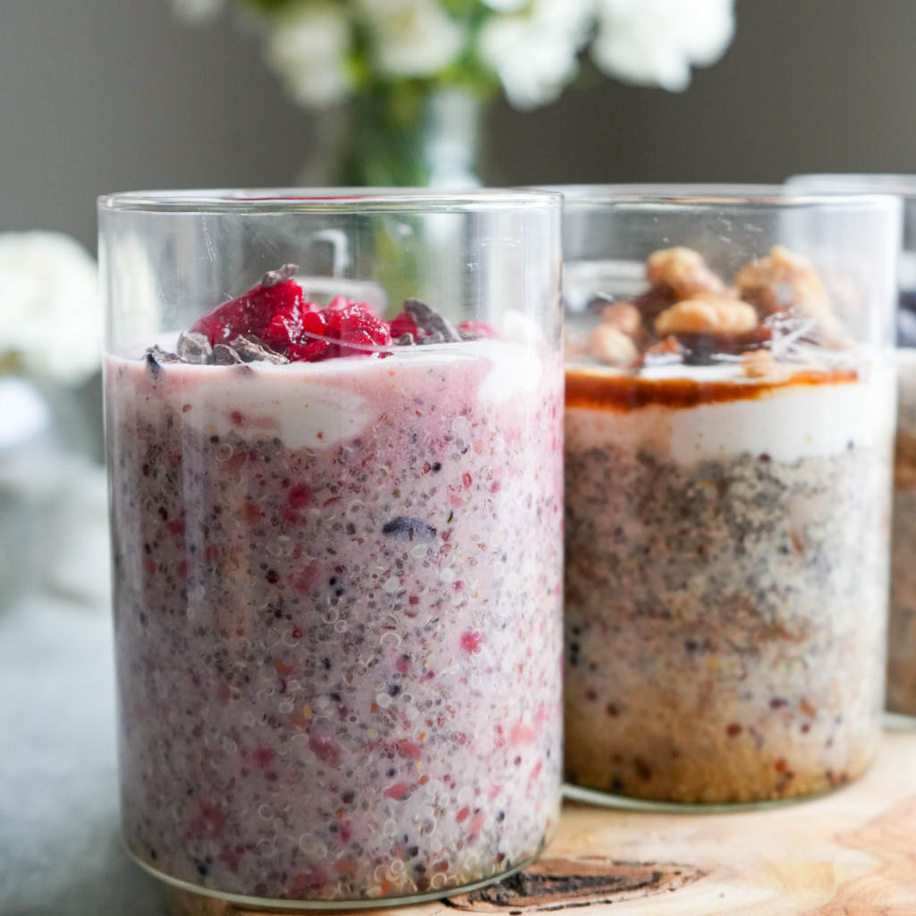 a mason jar filled with raspberry quinoa porridge next to a jar filled with apple cinnamon quinoa porridge