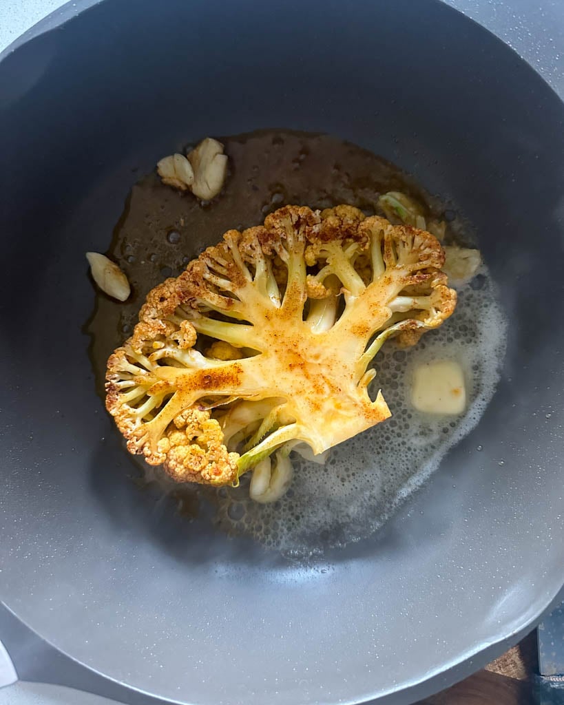 cauliflower steak frying in a pan