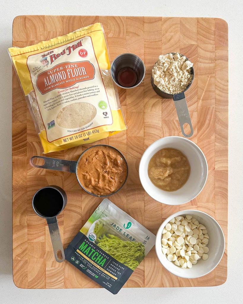 ingredients to make matcha cookies on a wooden cutting board