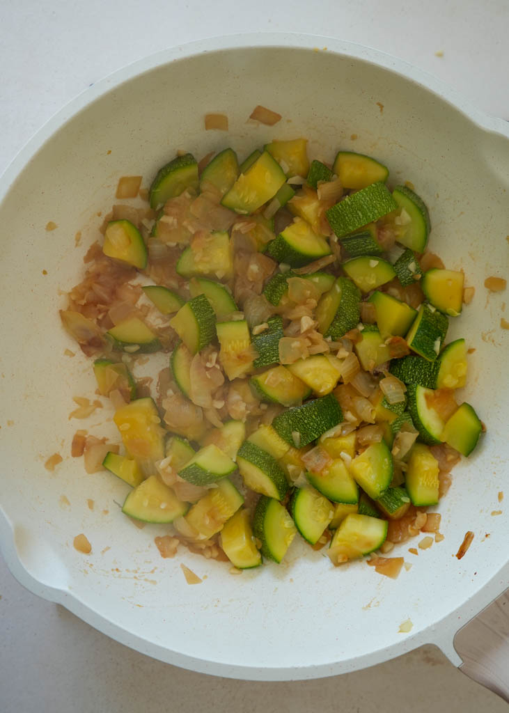 sauteed onions garlic and zucchini in a skillet