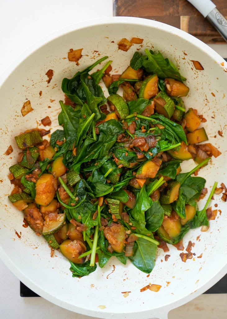 sauteed onions garlic spinach and zucchini in a skillet