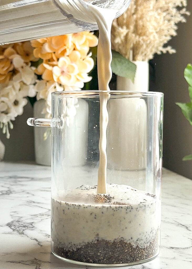 pouring hemp milk into mason jar with chia seeds