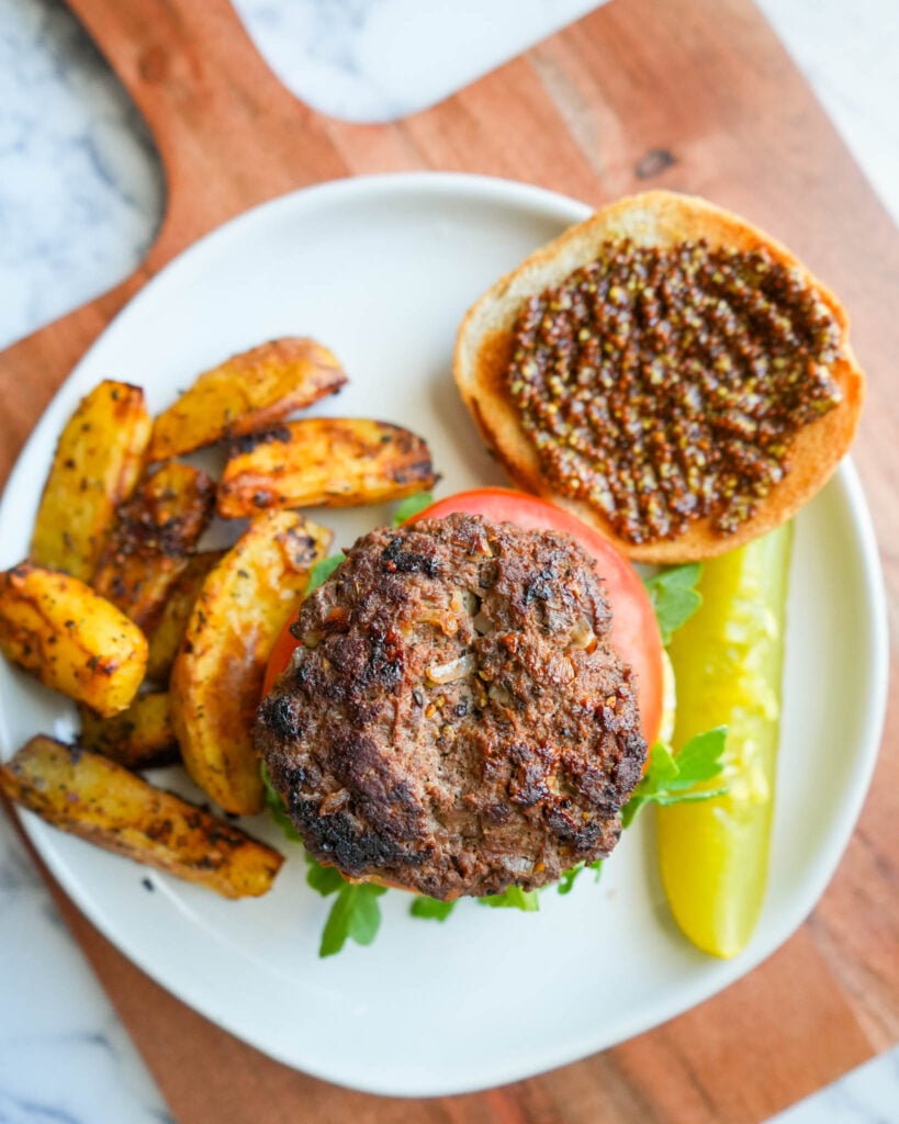 burger with toppings nad fries on a plate