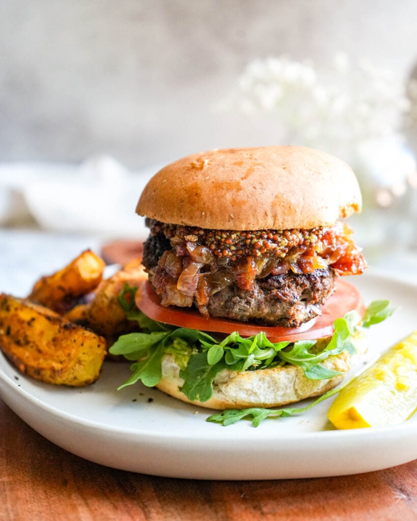 bison burger on a plate with fries and a pickle