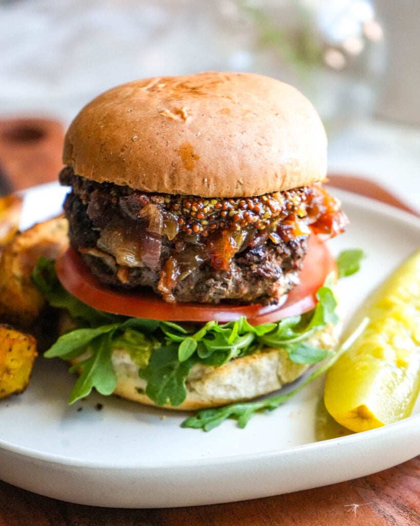 burger with toppings nad fries on a plate