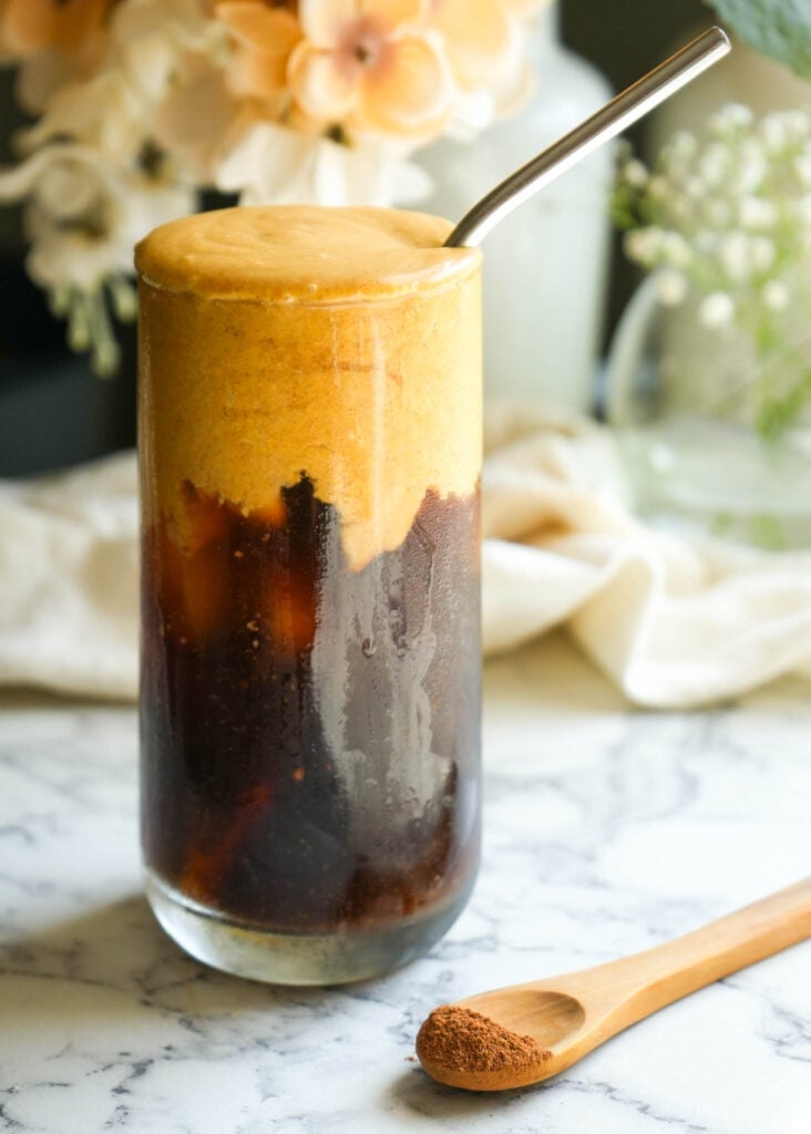 glass of cold brew topped with dairy free pumpkin cream cold foam