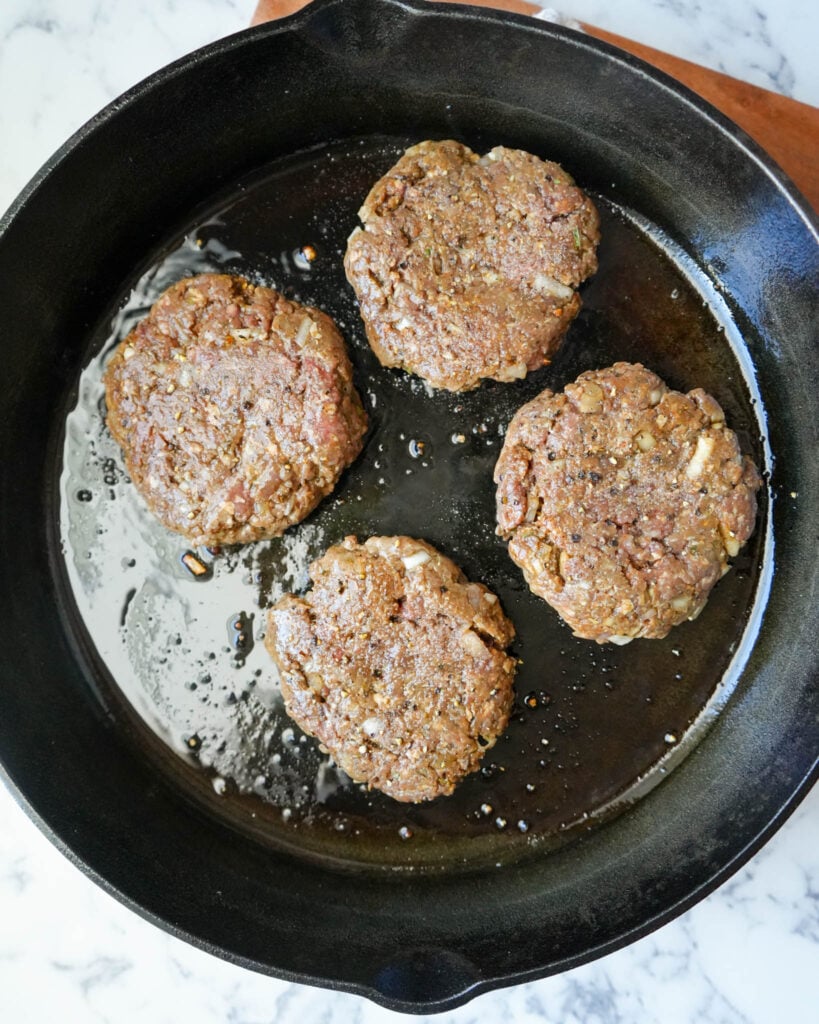 raw bison burgers in a cast iron