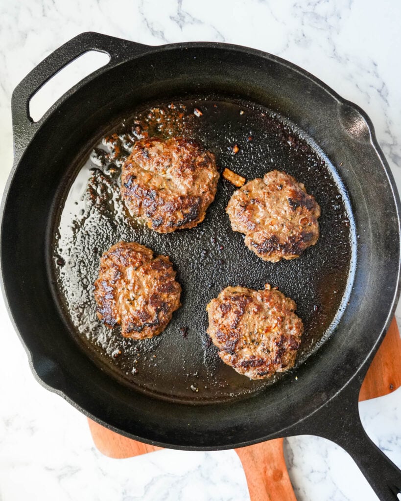 cooked bison burgers in a cast iron