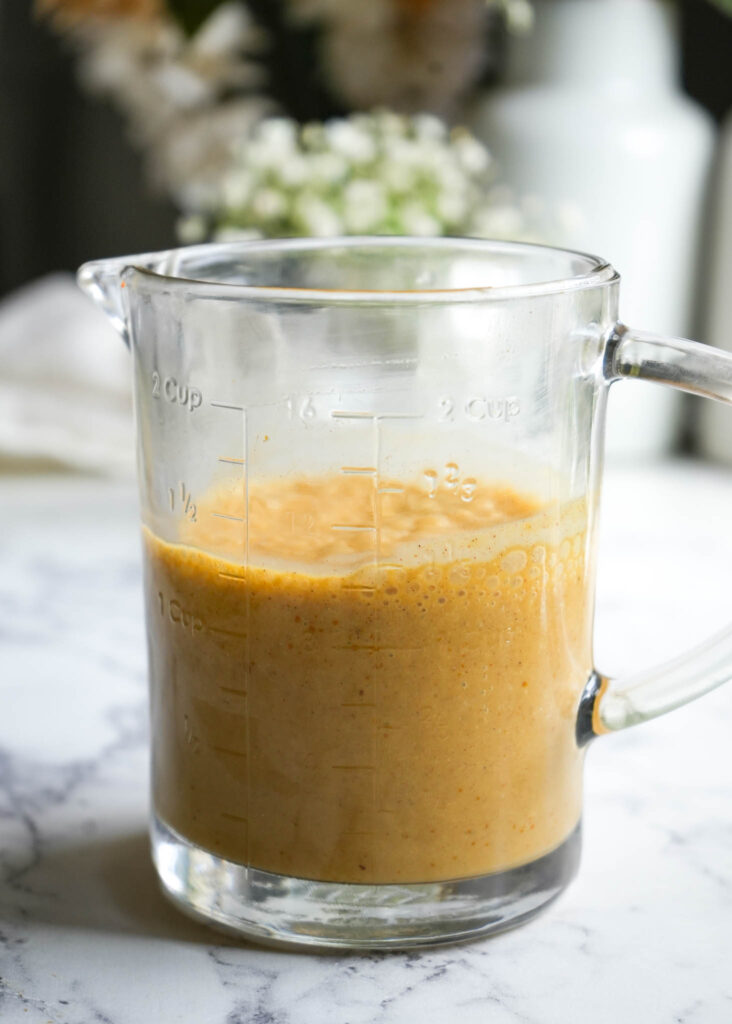 pumpkin cream cold foam in a measuring cup