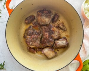 browned oxtails in a dutch oven