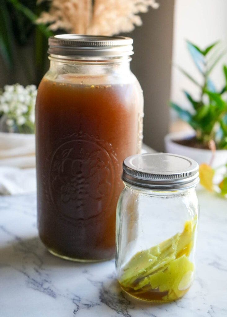 64 ounce mason jar filled with beef bone broth and a small mason jar with beef tallow in it