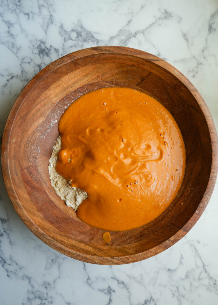 wet and dry ingredients to make pumpkin protein muffins in a large bowl