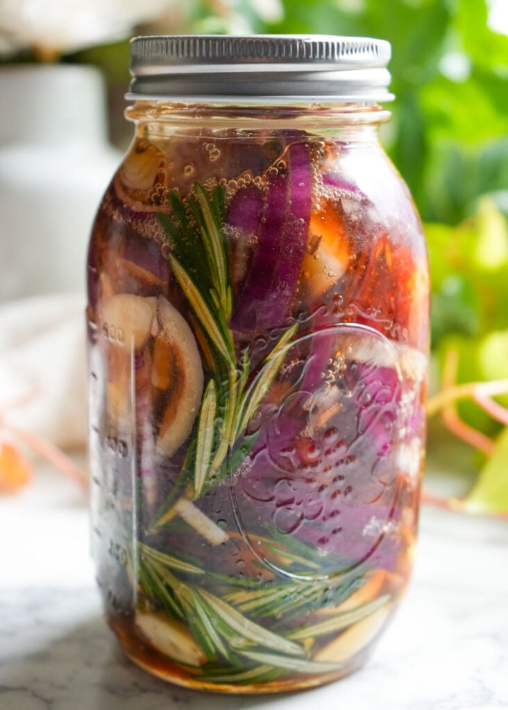 day one of fermenting 36 ounce mason jar filled with rosemary onion garlic cinnamon and honey to make honey cough syrup